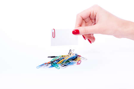 Woman hand with red manicure holdind paperclipの写真素材