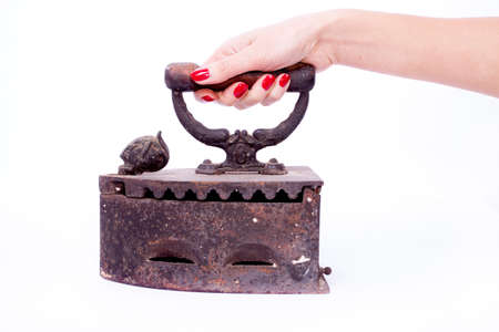 Woman hand wtih red manicure holding vintage ironの写真素材