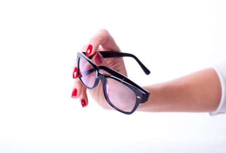 Woman hands red manicure holding black spectaclesの写真素材
