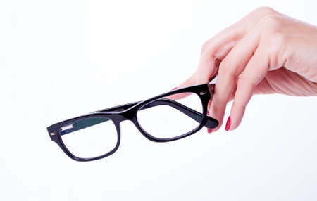 Woman hands red manicure holding black spectaclesの写真素材