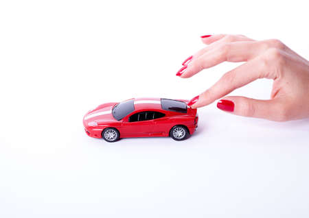 Toy red car on female hand on white backgroundの写真素材