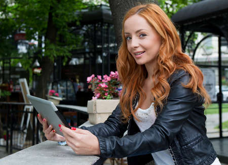 Portrait of a beautiful girl with a tablet in cafeの写真素材
