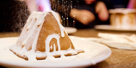 A close up of Gingerbread house under snow. a piece of cake.の写真素材