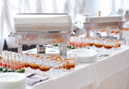 catering food on table glasses and platesの写真素材