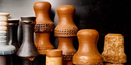 a few clay hookah cups near the black wall