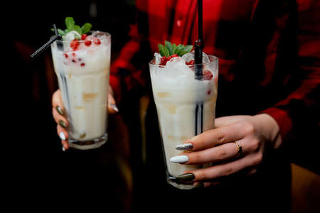 Girl waiter with two milkshakes in hand