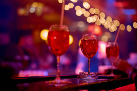 three red cocktails on the bar in the cafe