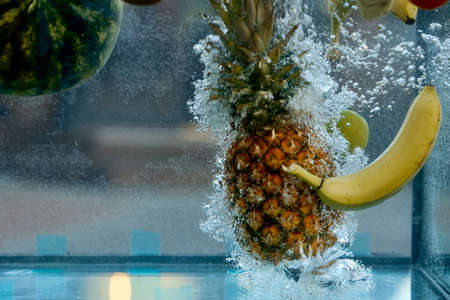 fruit pineapple and banana thrown into the water, bubbles appearedの写真素材