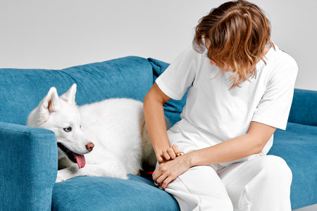 Woman and Husky Relaxing on Blue Sofa