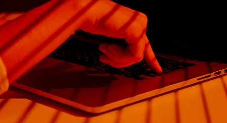 Finger Pressing Keyboard Button with Striped Light Shadows.