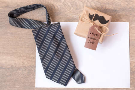 A gift, a blue tie, and a father's card. A striped tie on a sheet of white paper. Best quality gifts...