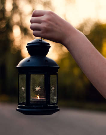 Happy Halloween. A womans hand holds a lantern. Twilight. Selective focus. High-quality photosの写真素材