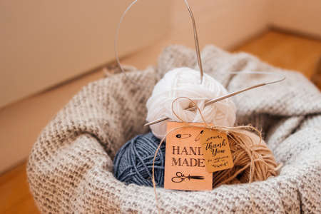 Balls of knitting thread in a basket with a blanket.