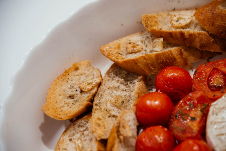 Camembert cheese baked with tomatoes and baguette, herbs and garlic. An excellent appetizer for wine. View from aboveの写真素材