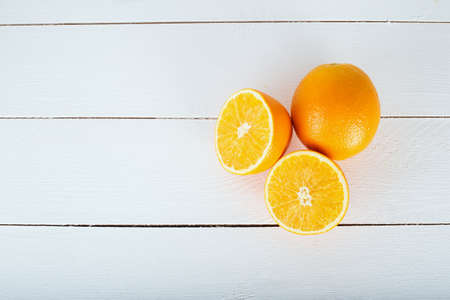 oranges and on a wooden borad on a white wooden backgroundの写真素材