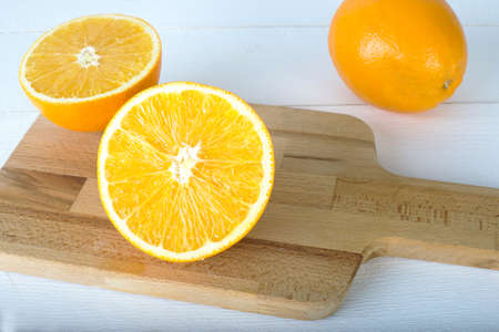 oranges on a wooden board on a white wooden backgroundの写真素材