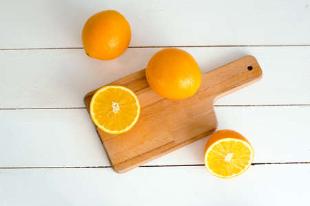 oranges and on a wooden borad on a white wooden backgroundの写真素材