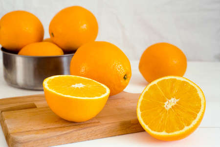 oranges and on a wooden borad on a white wooden backgroundの写真素材