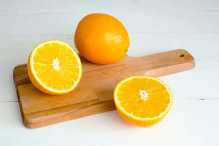 oranges and on a wooden borad on a white wooden backgroundの写真素材