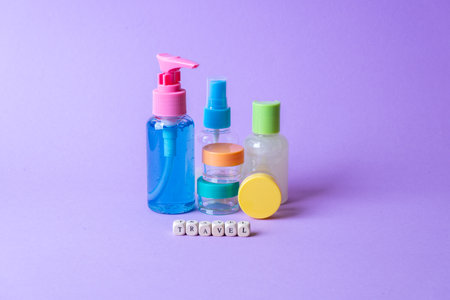 Set of full plastic travel bottles on lavender background. Travel kit with approved for airplane hand luggage bottle container size. Travel containers with colorful tops.の写真素材
