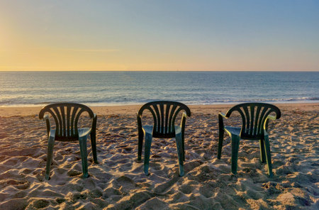 empty chairs on the beach at sunrise, beautiful photo digital picture.の写真素材