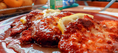 Pork chop with lemon and sauce on the plate in the restaurantの写真素材