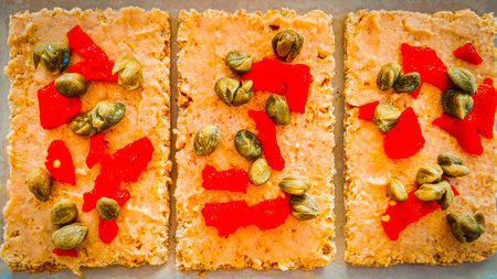 Cakes with red caviar and pistachios on a baking sheet