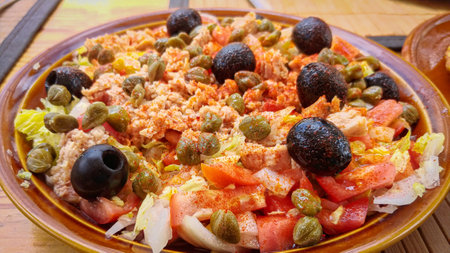 Salad with tuna, olives and capers on wooden tableの写真素材