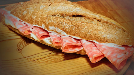 sandwich with ham and cheese on a wooden table. Toned.の写真素材