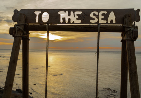 Wooden sign with the text to the sea at sunset time.の写真素材