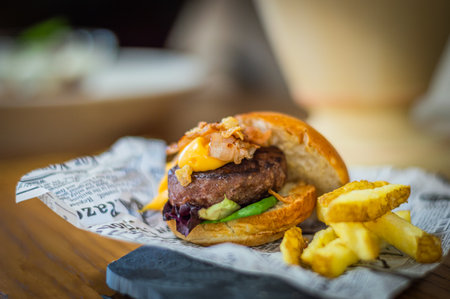 Cheese burger - American cheese burger with Golden French fries on wooden tableの写真素材