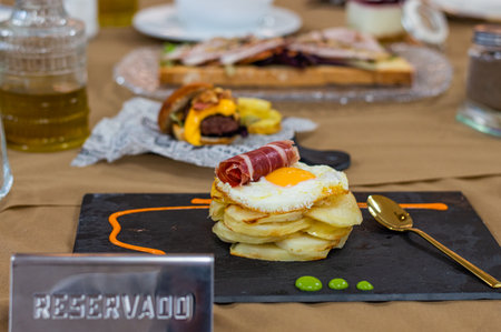 Fried eggs and bacon on a plate on a table with coffeeの写真素材