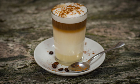 Cappuccino with whipped cream and coffee beans on the tableの写真素材