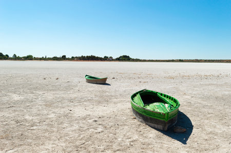 Fishing boats on the salt lake at low tide with clear blue skyの写真素材