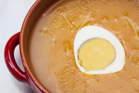 A bowl of chicken noodle soup with eggの写真素材