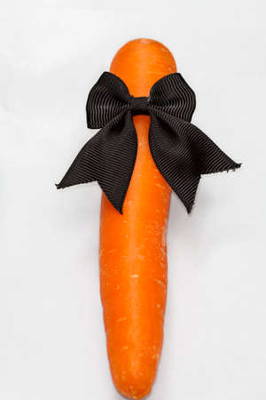 carrot with black ribbon isolated on whiteの写真素材