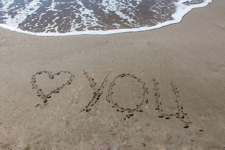 I Love you written on sand with wave rollingの写真素材