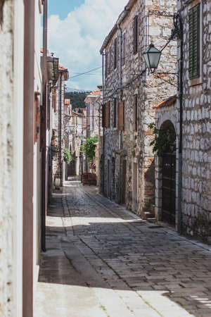 Narrow old streets in the town of Starigrad on the island Hvar. Old greek style stone houses and a narrow paved footroad going through themの写真素材