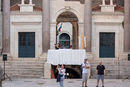 Peristil area inside the Diocletians palace, arch covered in white cloth and a cross, celebration of the "Tijelovo" ceremony. People gathered in front, journalist taking photosのeditorial素材