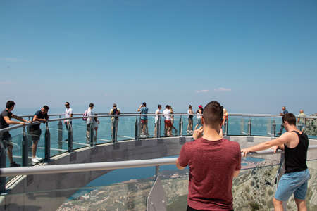 Tourists walking accross the newly built skywalk on Biokovo mountain. Two men in foreground taking a photo, admiring from the distanceのeditorial素材
