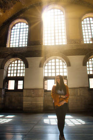 Istanbul Turkey October 2019 Attractive girl posing inside the Hagia Sophia church, illuminated by the sun through huge windows. Influencer on social media conceptのeditorial素材