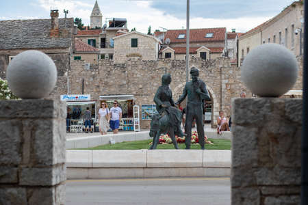 Primosten Croatia July 2020 Statue of a person riding on a donkey in front of the old town of...