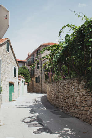 Small old stone street going through the town of Postira on the island of brac in croatiaの写真素材