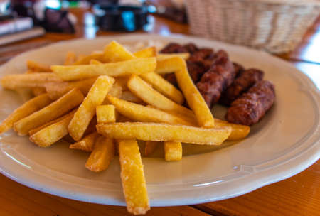 Cevapi, traditional balkan minced meat dish served with french fries in a restaurant on the adriatic...