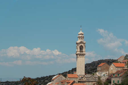 Tall belltower in a tiny village of Lozisca on the island of Brac, Croatia. Beautiful christian...