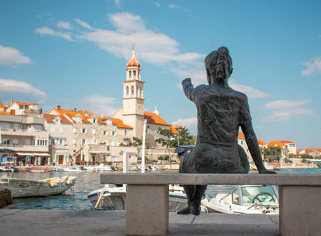 Statue of a little girl pointing at the belltower in the coastal small town of Sutivan on the island...