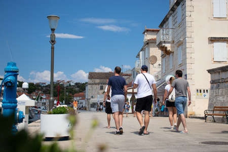 Milna Croatia August 2020 A group of tourists walking along the promenade of a costal town of milna on the island of bracのeditorial素材