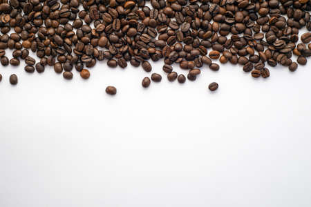 Brown coffee beans on white paperの写真素材
