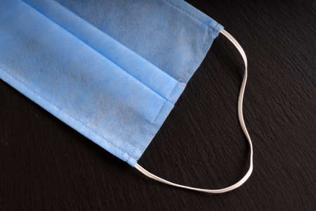 medical mask on a black background, top view