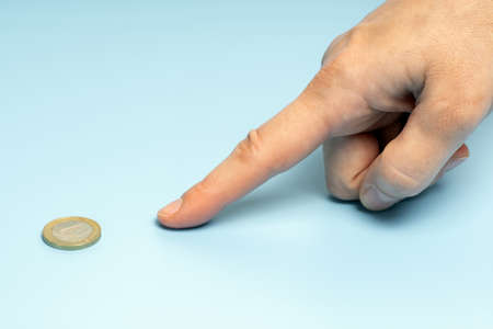 female finger points to one euro coin.の写真素材